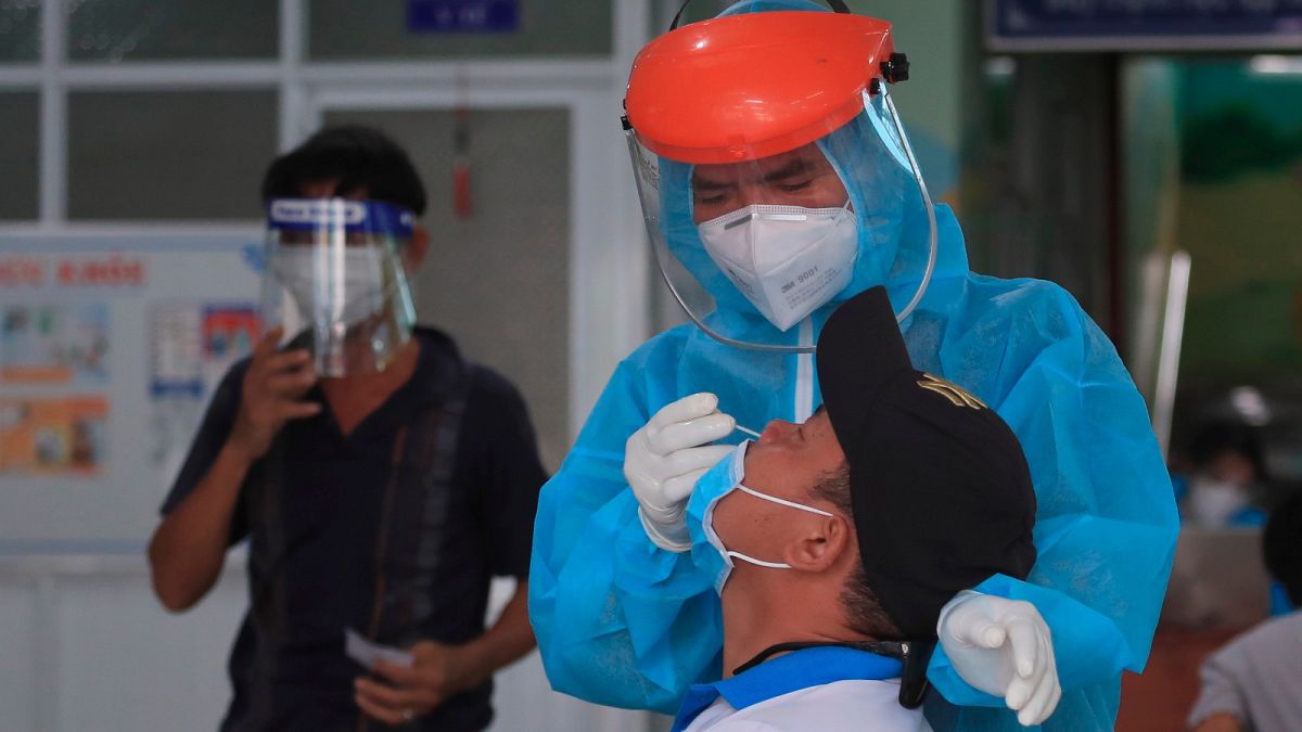 A medical worker takes swab sample from a man in Vung Tau city, Vietnam Saturday, Aug. 21, 2021. 