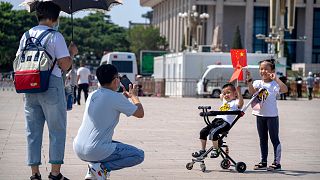 Children hold Chinese flags as they pose for a photo at Tiananmen Square in Beijing, on June 22, 2021.