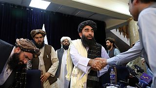المتحدث باسم طالبان ذبيح الله مجاهد يصافح صحفيًا بعد مؤتمره الصحفي الأول في كابول، الثلاثاء 17 أغسطس 2021