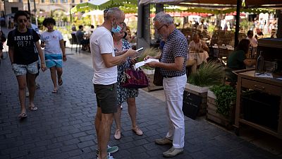 A restaurant owner scans a health pass at a restaurant in Marseille, southern France, Monday, Aug. 9, 2021.