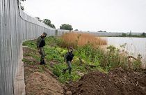In this May 21, 2021, file photo, policemen patrol alongside a steel wall at Evros river, near the village of Poros, at the Greek -Turkish border, Greece. 