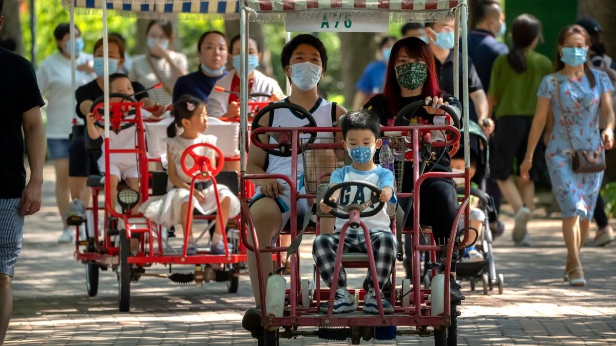 Adults and children ride pedal cycles at a public park in Beijing, Saturday, Aug. 21, 2021.