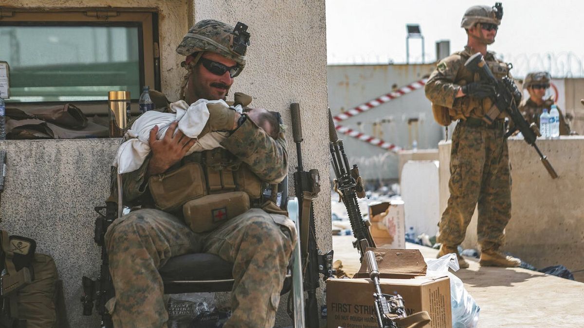 Ein US-Marine am Hamid-Karzai-Flughafen kümmert sich um ein afghanisches Baby