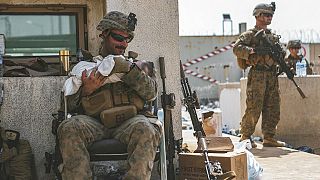 Ein US-Marine am Hamid-Karzai-Flughafen kümmert sich um ein afghanisches Baby