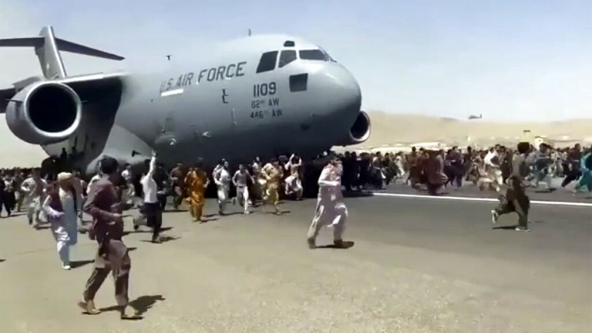 مئات الأشخاص يركضون جنباً إلى جنب مع طائرة نقل تابعة للقوات الجوية الأمريكية أثناء تحركها على مدرج المطار الدولي في كابول - 16 آب / أغسطس 2021