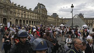 متظاهرون يسيرون في باحة متحف اللوفر خلال مظاهرة ضد البطاقة الصحة، السبت 21 أغسطس 2021 في باريس