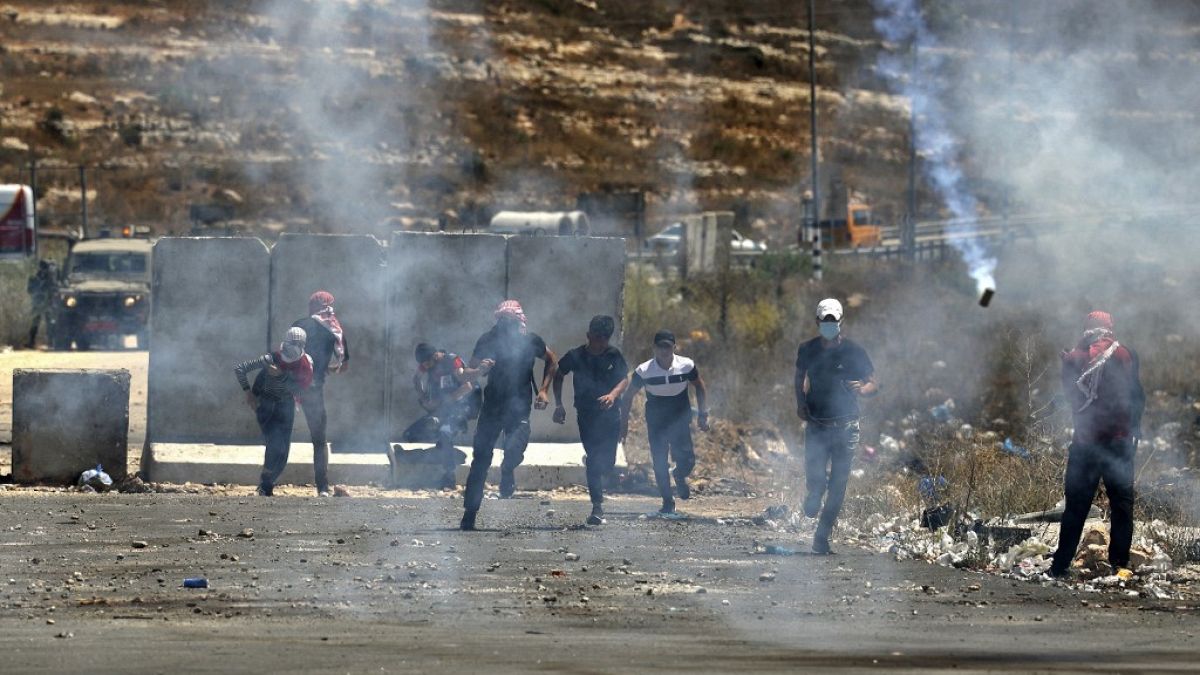   فلسطينيون يهرعون لتجنب قنابل الغاز المسيل للدموع  خلال مظاهرة في 17 أغسطس 2021