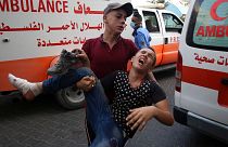 A protestor helps a wounded youth, who was shot by Israeli troops in his foot during a protest at the Gaza Strip's border with Israel.