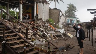 A man inspects the damage after a part of his home was toppled by winds brought on by Hurricane Grace, in Tecolutla, Veracruz State, Mexico.