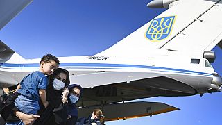 People evacuated from Afghanistan disembark from a Ukrainian military plane at Boryspil International Airport outside Kyiv, Ukraine