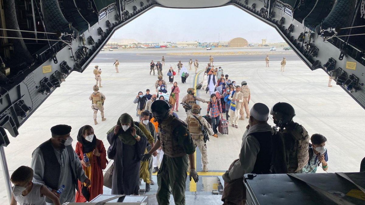 Katonák segítenek beszállni a menekülő embereknek egy szállító repülőgépbe a kabuli repülőtéren 2021. augusztus 18-án