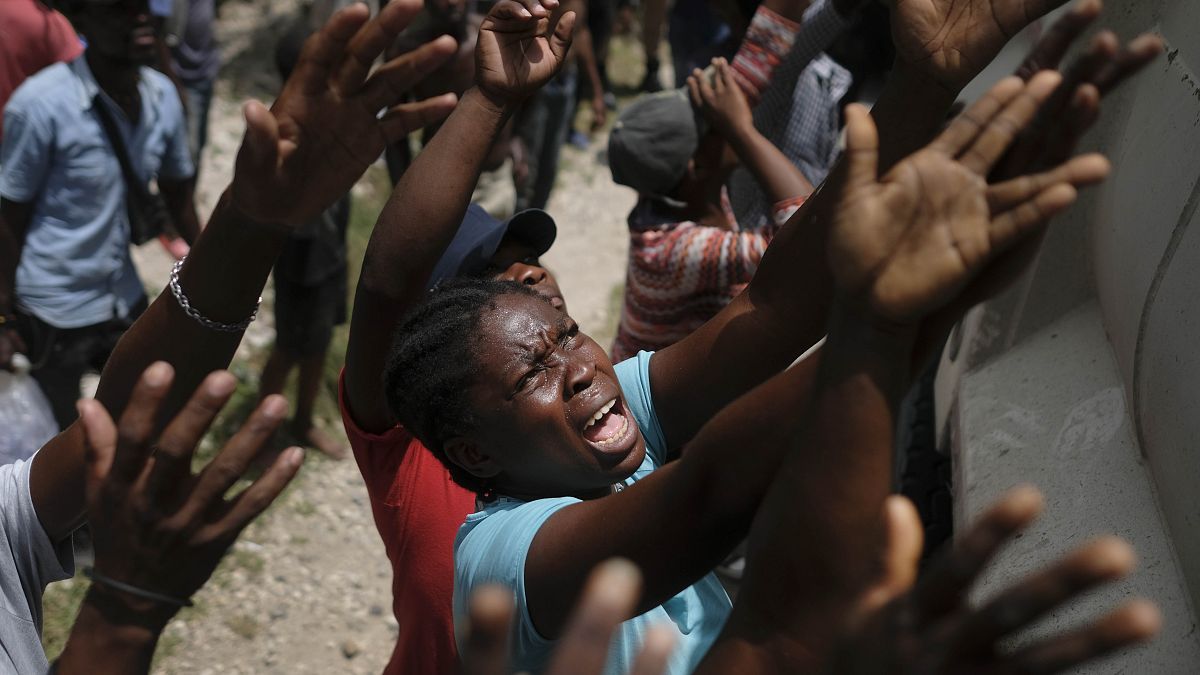 Des haïtiens attendent une distribution d'eau à Cayes, le 22 août 2021