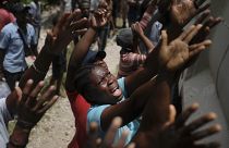 Des haïtiens attendent une distribution d'eau à Cayes, le 22 août 2021