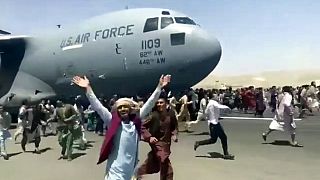 مئات الأشخاص يركضون جنبا إلى جنب مع طائرة نقل تابعة للقوات الجوية الأمريكية أثناء تحركها على مدرج المطار الدولي، في كابول - 16 أغسطس 2021