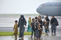 عدد من النسوة الأفغانيات مع أطفالهن يهبطون في قاعدة جوية هندية قرب العاصمة نيودلهي في الهند. 22/08/2021