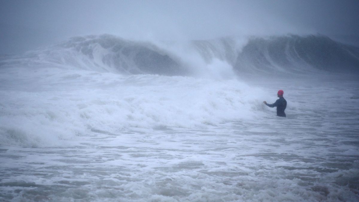 Matt Prue, from Stonington, Conn., walks out into the Atlantic Ocean to body surf the waves from Tropical Storm Henri as it approaches Westerly, R.I., Sunday, Aug. 22, 2021.