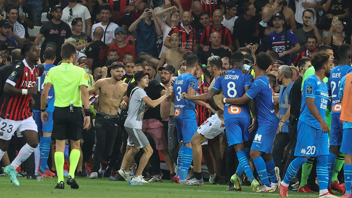 Fans invade the pitch during the French L1 football match between OGC Nice and Olympique de Marseille (OM) at the Allianz Riviera stadium in Nice, France on August 22, 2021.