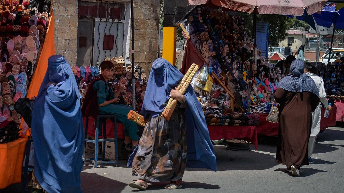 Taliban'ın ülkeyi ele geçirmesinin ardından burka giyinen Afgan kadınlar pazar alanında alışveriş yapıyor 