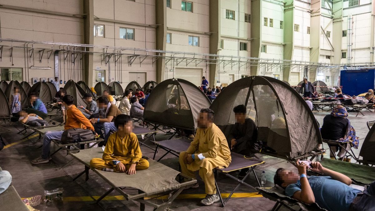 Refugees wait at an evacuation centre after they left Kabul as part of the operation "Apagan" at the French military air base of Al Dhafra, near Abu Dhabi, on August 23, 2021.