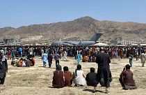  Des centaines de personnes se rassemblant près d'un avion de transport C-17 de l'armée de l'air américaine, sur l'aéroport international de Kaboul, en Afghanistan, le 16 août