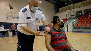 A paramedic with Israel's Magen David Adom medical service administers the third shot of the Pfizer-BioNTech Covid-19 vaccine on August 24, 2021 in Holon.