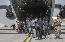 Családok szállnak be egy amerikai kimenekítő repülőgépbe a kabuli reptéren
