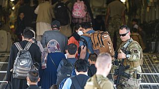 In this image provided by the U.S. Air Force, U.S. Air Force airmen guide evacuees aboard a US Air Force plane at Hamid Karzai International Airport, August 24, 2021.
