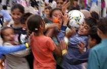 Recently evacuated young Afghans play with a ball at the Ramstein U.S. Air Base, Germany, Tuesday, August 24, 2021. 
