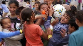 Recently evacuated young Afghans play with a ball at the Ramstein U.S. Air Base, Germany, Tuesday, August 24, 2021.
