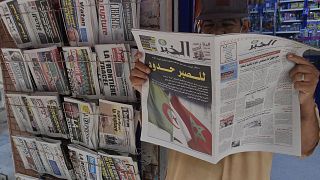 رجل جزائري يمسك بجريدة في العاصمة الجزائر. 2021/08/25
