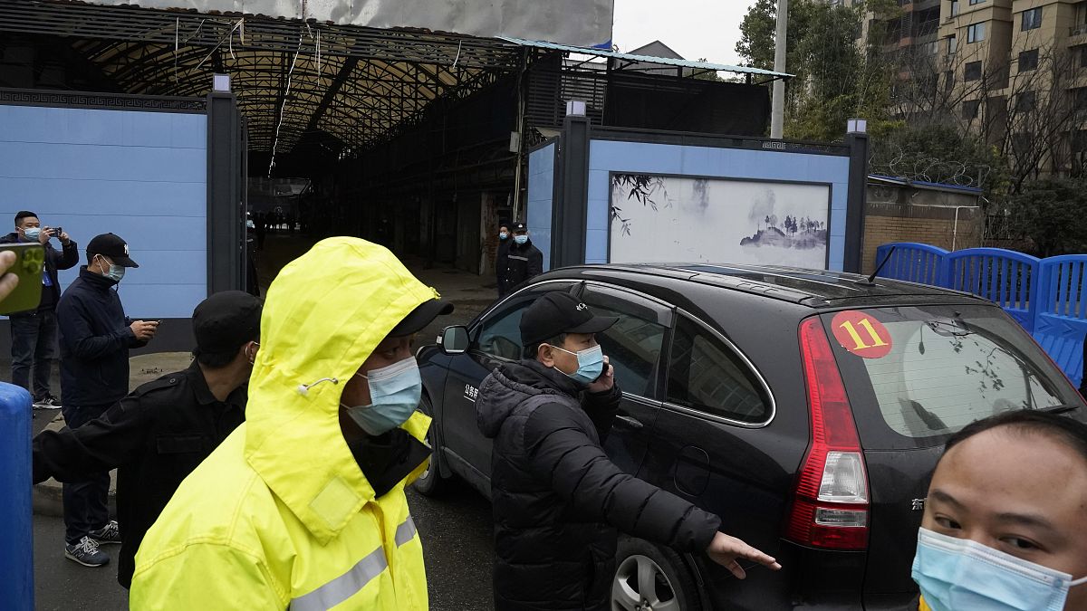 Security personnel clear the way for a convoy of the World Health Organization team to enter the Huanan Seafood Market in Wuhan in January 2021.