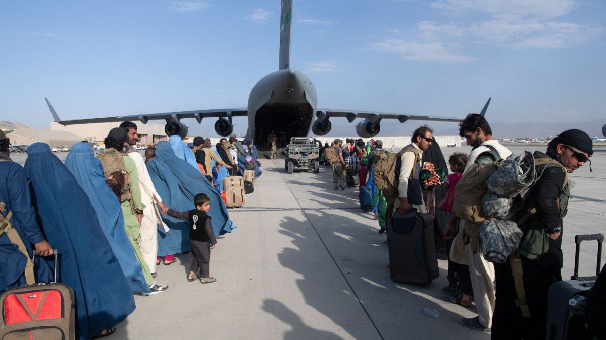 This handout photo from the US Air Force shows evacuees boarding a US transport plane at Hamid Karzai International Airport (HKIA), Afghanistan, August 24, 2021.