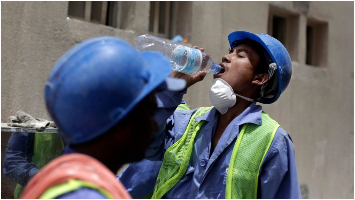 عامل نيبالي يشرب الماء أثناء عمله في أحد المشاريع بالعاصمة القطرية الدوحة