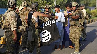 صورة من الارشيف - عنصر أمني أفغاني يحمل علم تنظيم الدولة الإسلامية بعد هجوم في مدينة جلال آباد، شرق كابول، أفغانستان، 3 أغسطس، 2020