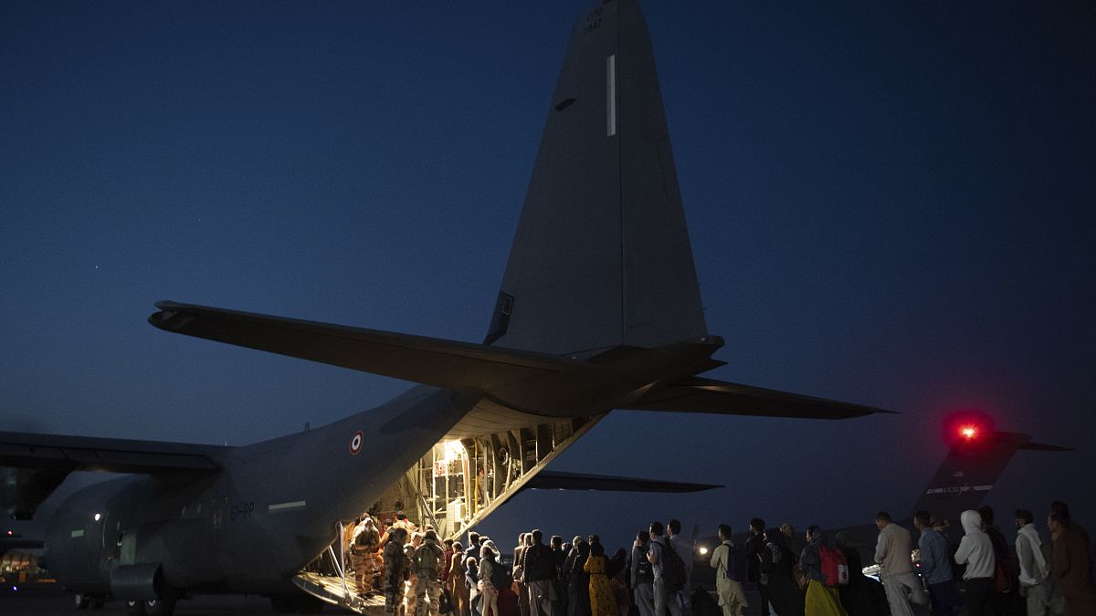 Cette photo prise le 26 août 2021 montre des personnes embarquant dans un avion militaire français à l'aéroport de Kaboul