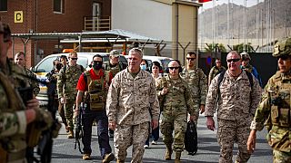 القائد العام للقيادة المركزية الأمريكية كينيث ماكنزي، وسط الصورة، يقوم بجولة في مركز مراقبة الإخلاء في مطار حامد كرزاي الدولي، أفغانستان، ا 17 أغسطس 2021