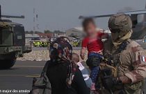 Image d'un soldat français tenant par la main un enfant afghan sur l'aéroport de Kaboul, Afghanistan, 23 août 2021
