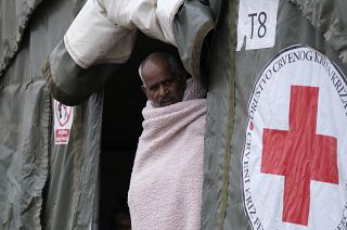 A migrant walks through the Lipa camp, outside Bihac, Bosnia, Thursday, Aug. 26, 2021