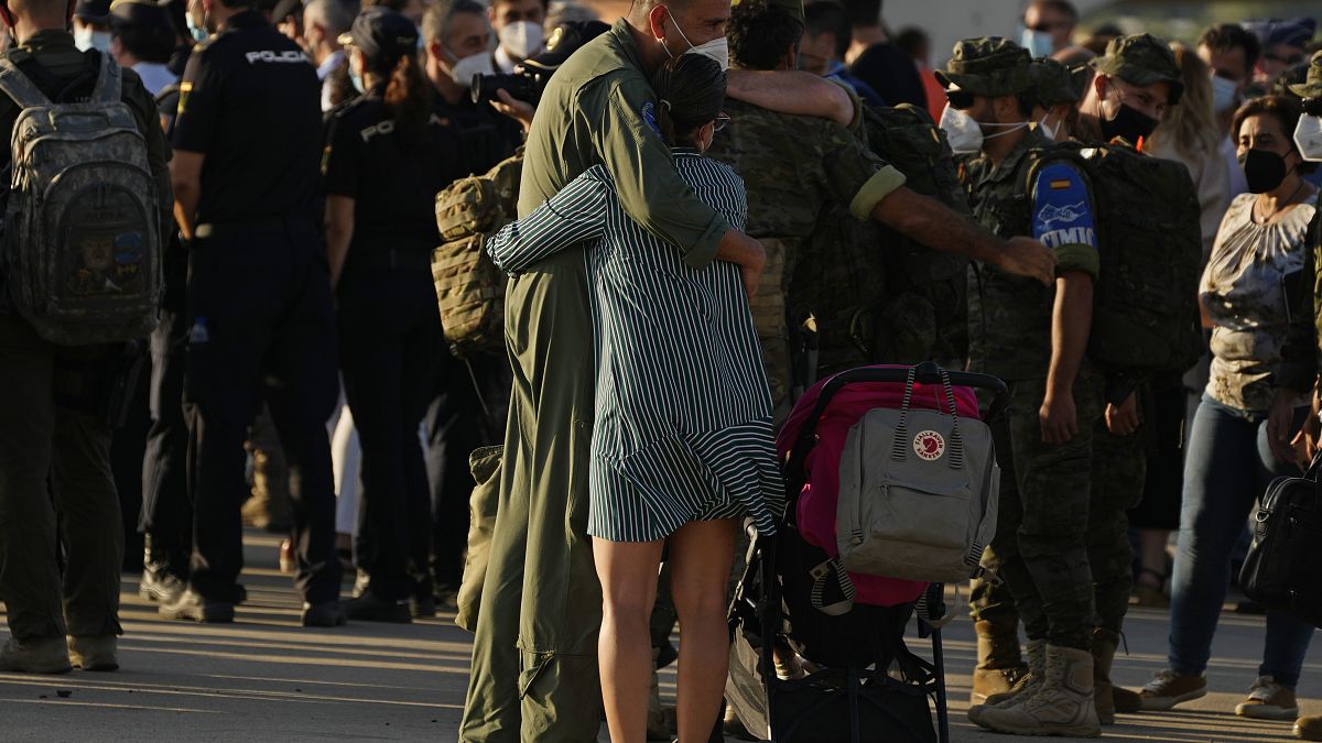 Un soldado español abraza a una mujer tras la llegada del avión procedente de Afganistán A la base militar de Torrejón de Ardoz en Madrid, el 27 de agosto de 2021.