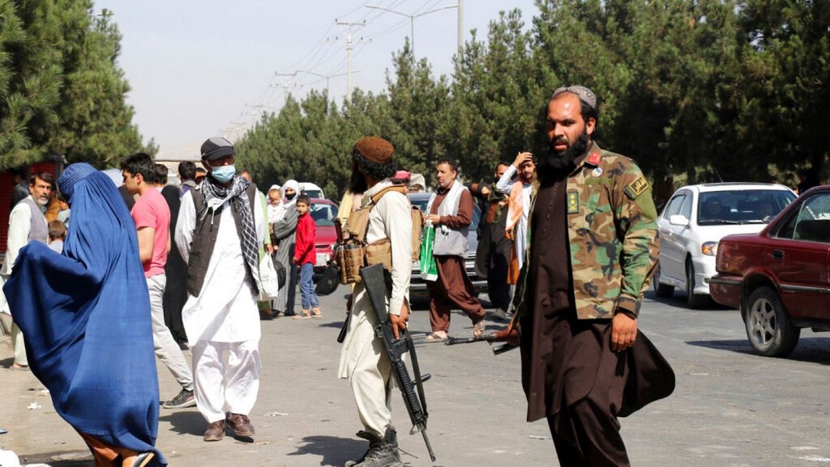 Taliban fighters stand guard outside the airport after Thursday's deadly attacks