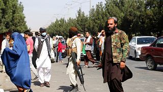 Taliban fighters stand guard outside the airport after Thursday's deadly attacks