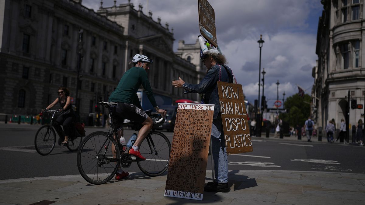 متظاهر من دعاة حماية البيئة يقف بالقرب من مقر البرلمان في لندن ، يوم الاثنين 9 أغسطس 2021.