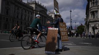 متظاهر من دعاة حماية البيئة يقف بالقرب من مقر البرلمان في لندن ، يوم الاثنين 9 أغسطس 2021.