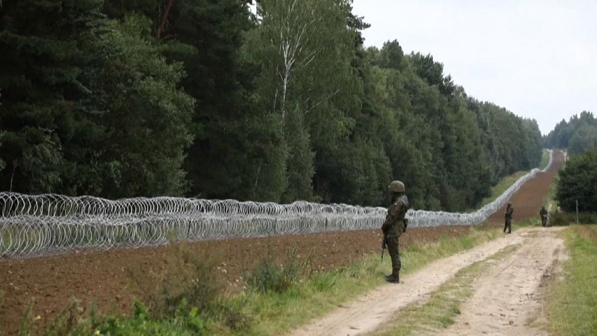 جندي بولندي أمام السياج الشائك على الحدود مع بيلاروس 