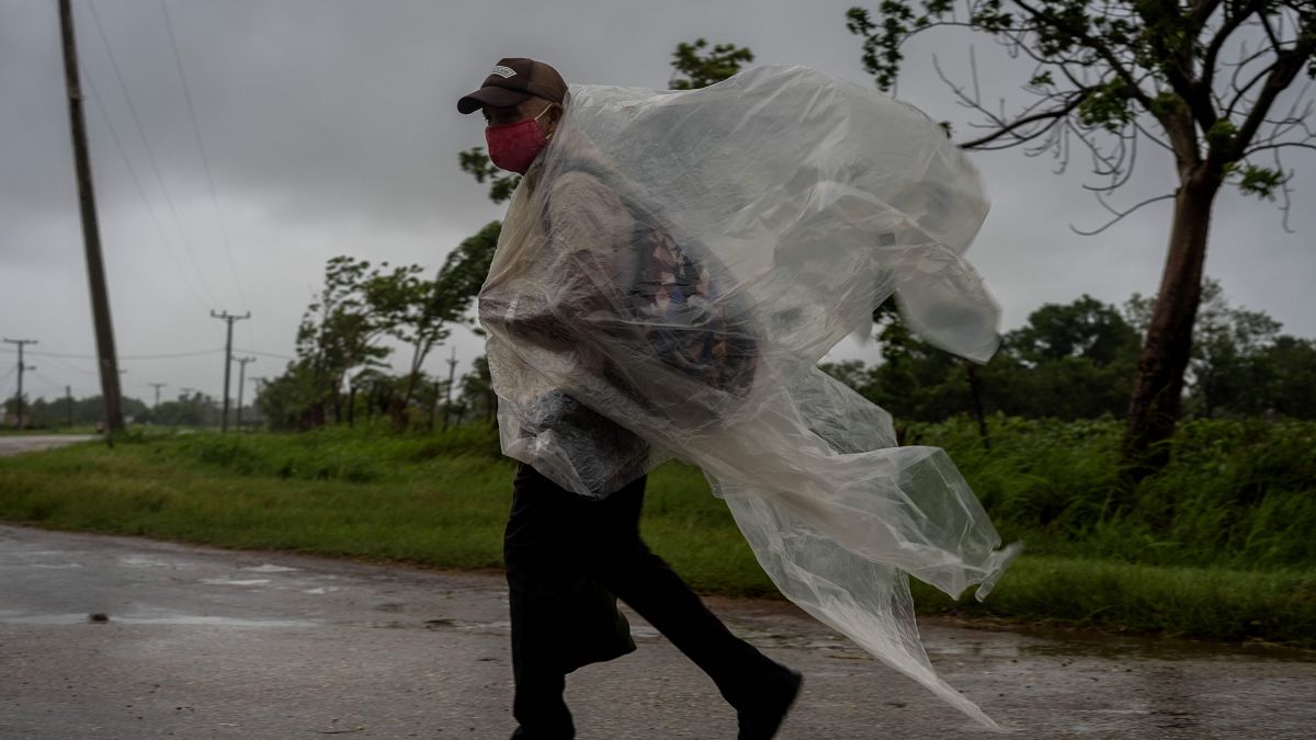 Un hombre se protege de la lluvia con un plástico en Cuba