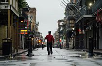 A man walks down a mostly deserted Bourbon Street in the French Quarter as the early effects of Hurricane Ida are felt, Sunday, Aug. 29, 2021, in New Orleans, La. 