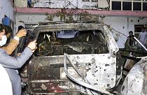 Des journalistes afghans prennent en photo un véhicule détruit à Kaboul le 29 août 2021