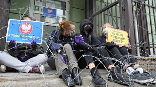 Protesters chained themselves to the fence surrounding the headquarters of Poland's Border Guards to protest the government's refusal to let in a group of illegal migrants.