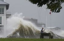 A man takes pictures of high waves along the shore of Lake Pontchartrain as Hurricane Ida nears, Aug. 29, 2021, in New Orleans.