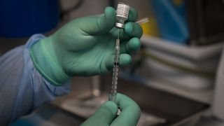 A health worker prepares a syringe with the Pfizer COVID-19 vaccine on Aug. 26, 2021, in Santa Ana, Calif.